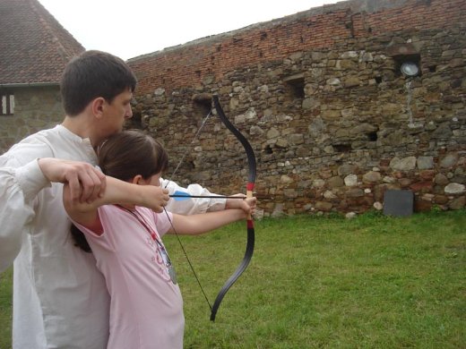 Ez nem játék, igazi íj és nyílvessző, amely egy kis segítséggel nem a várfalba, hanem a céltábla kellős közepébe fúródik.